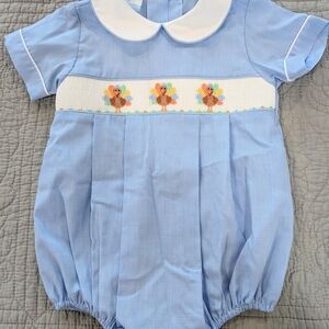 Petit Bebe boy's blue gingham bubble romper featuring smocked turkeys. 